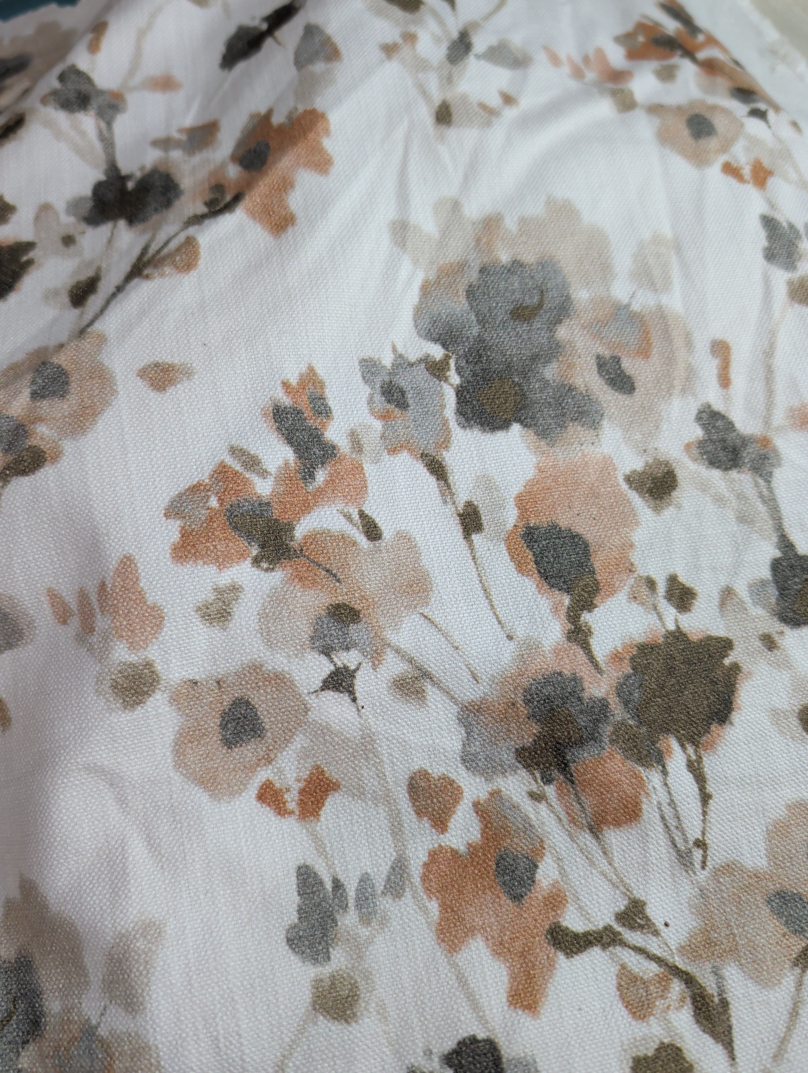 Floral patterned fabric with brown, black, and gray flowers on a white background