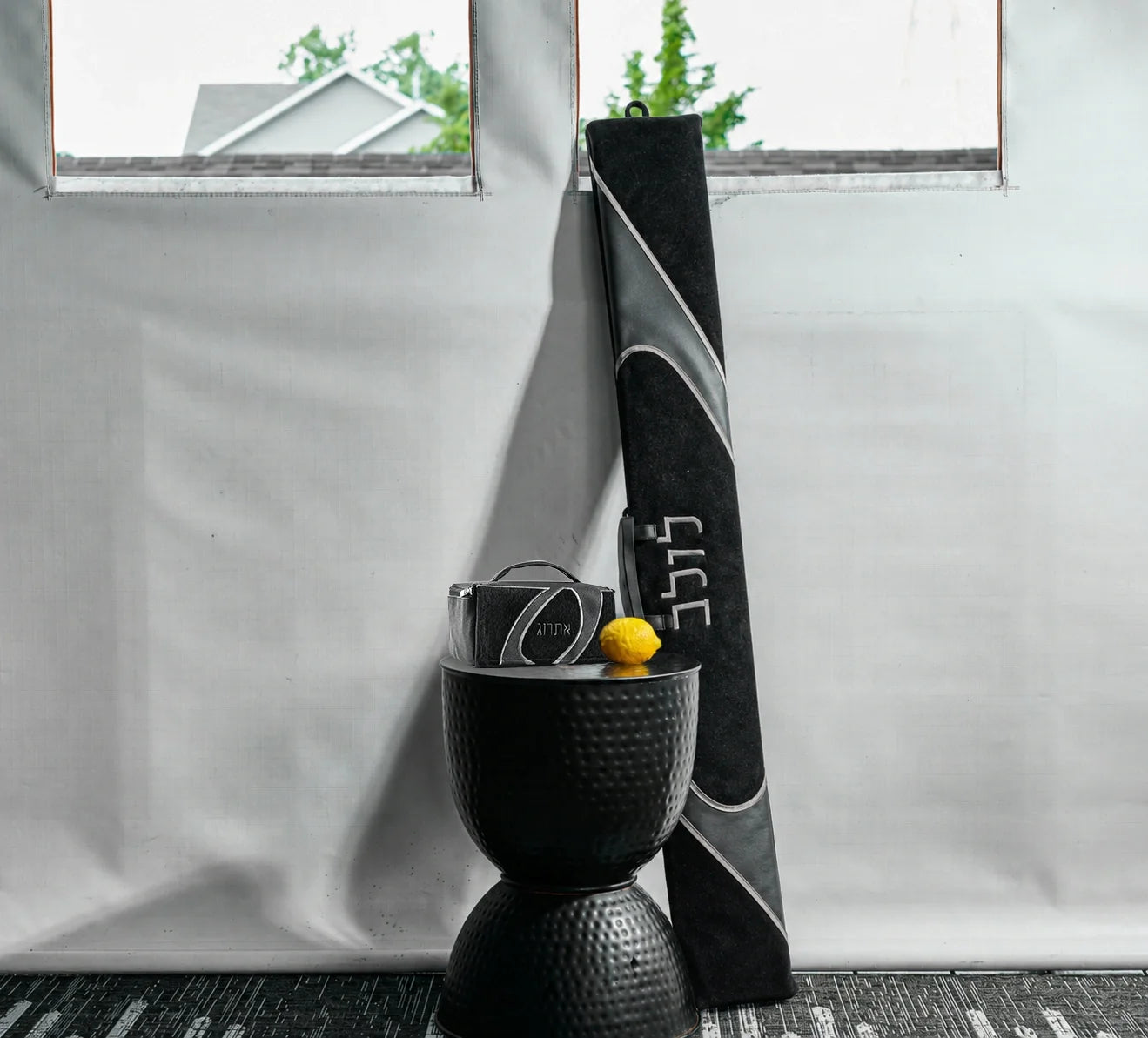 A lifestyle image of a coordinating black and gray faux leather lulav and esrog case for Succos