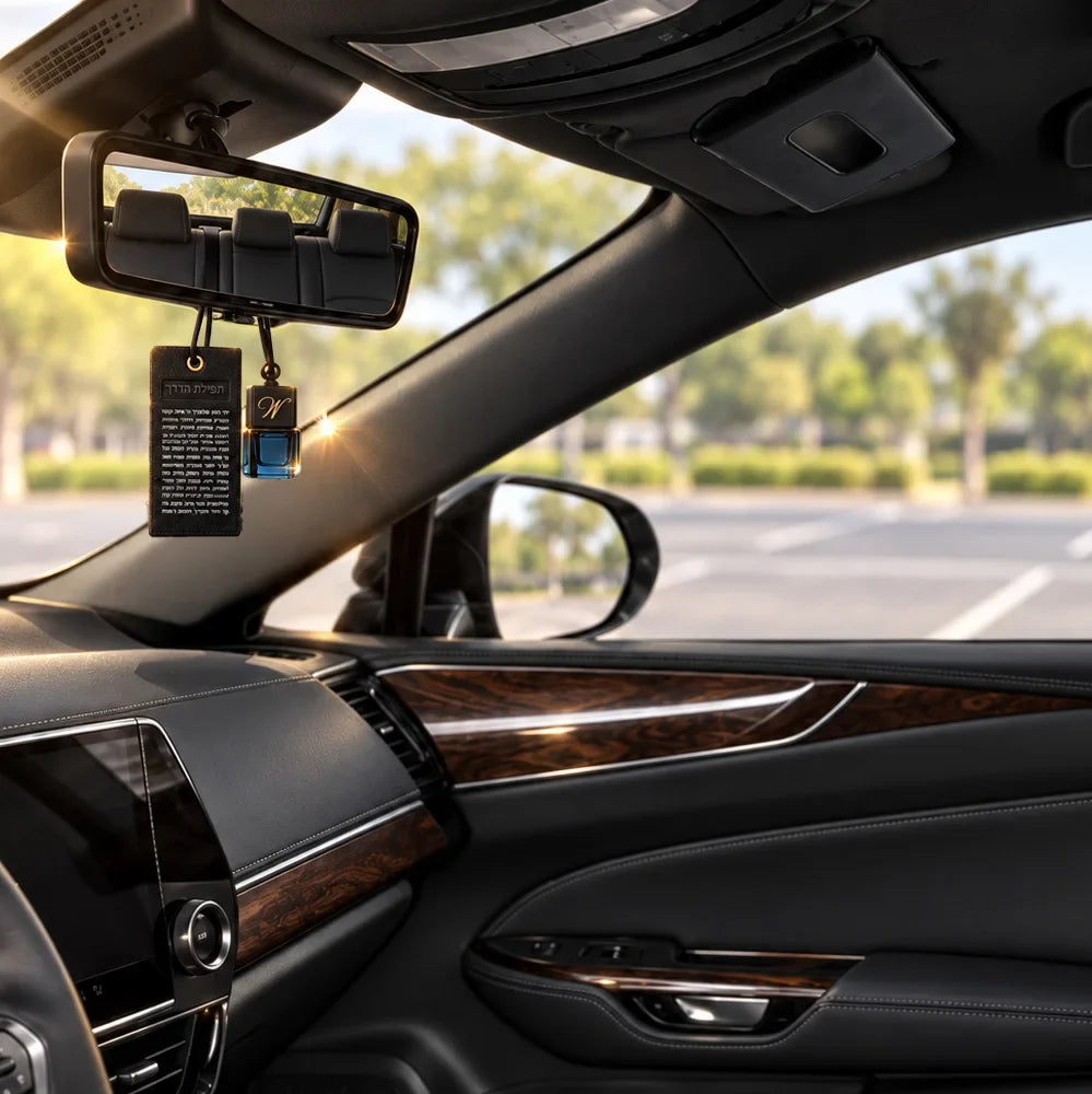 Tefillas Haderech tag and car diffuser hanging from a rearview mirror inside a car
