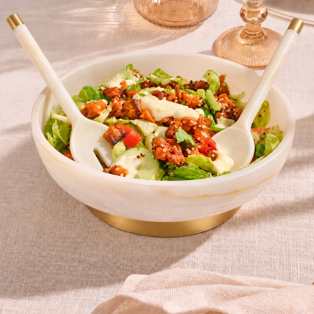 Marble resin salad servers tossing a salad in a resin bowl on a set Shabbos table