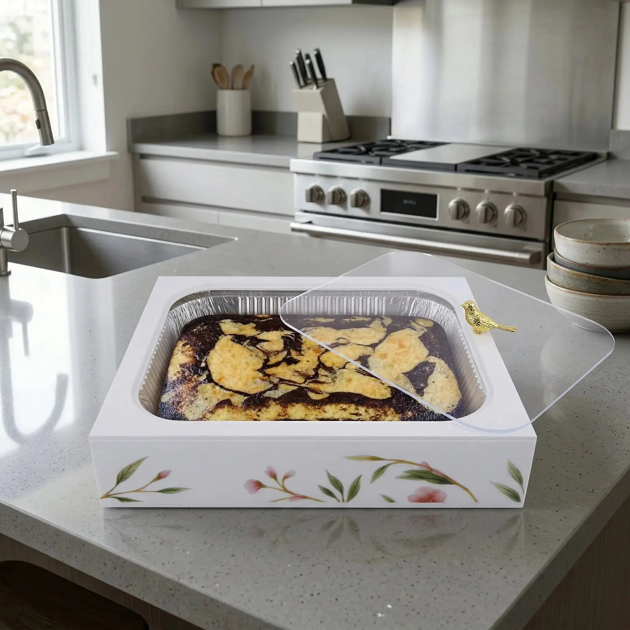Floral Bird 9x13 pan holder with delicate botanical design sits on marble counter displaying roasted vegetables in modern kitchen.