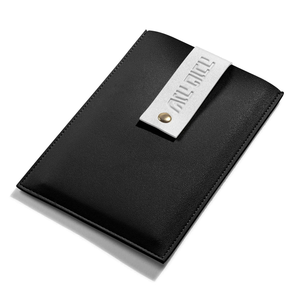 Black leather Simanim pouch with white card set label, closed flat lay view of this holiday judaica accessory.