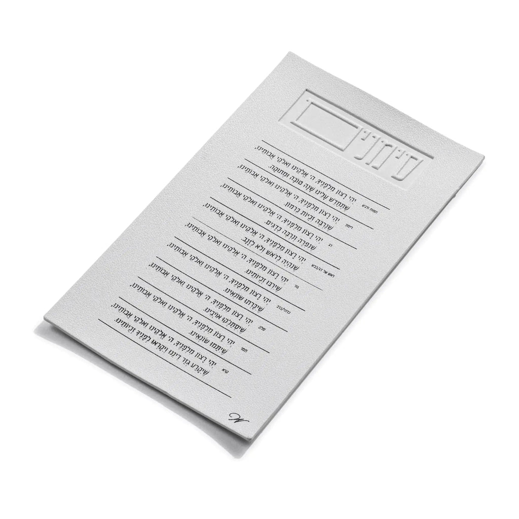 White lucite card from Waterdale Collection's Simanim set, displaying Hebrew text for Rosh Hashanah blessings and holiday traditions in clear lettering.