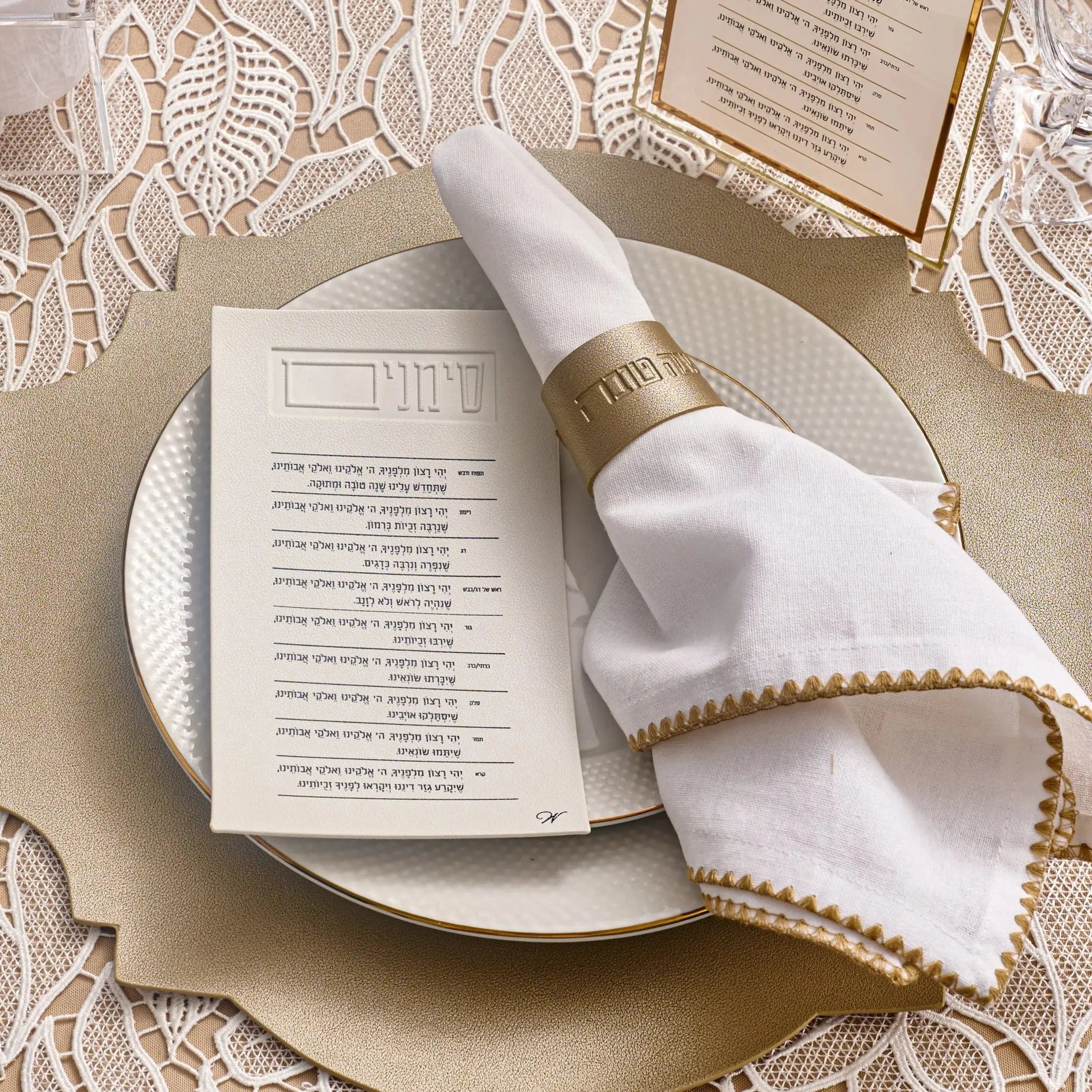 Gold leather napkin wraps on white plates with menu card, Rosh Hashana table setting by Waterdale Collection