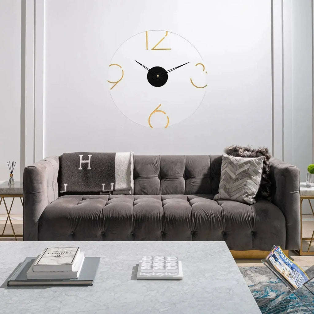 Gold Number Clock with black center and metal frame hanging above gray sofa in modern living room setting