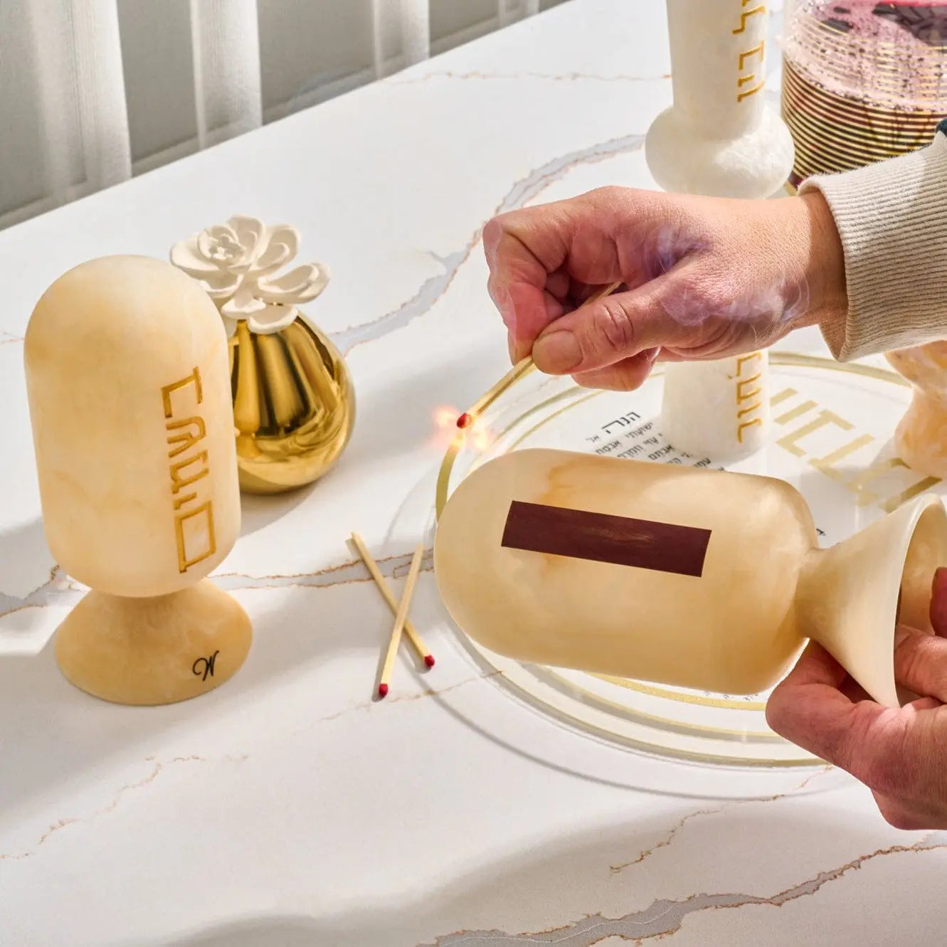 Gold resin besamim clove holder with metal accent details, displayed on white surface for Shabbat and holiday use.