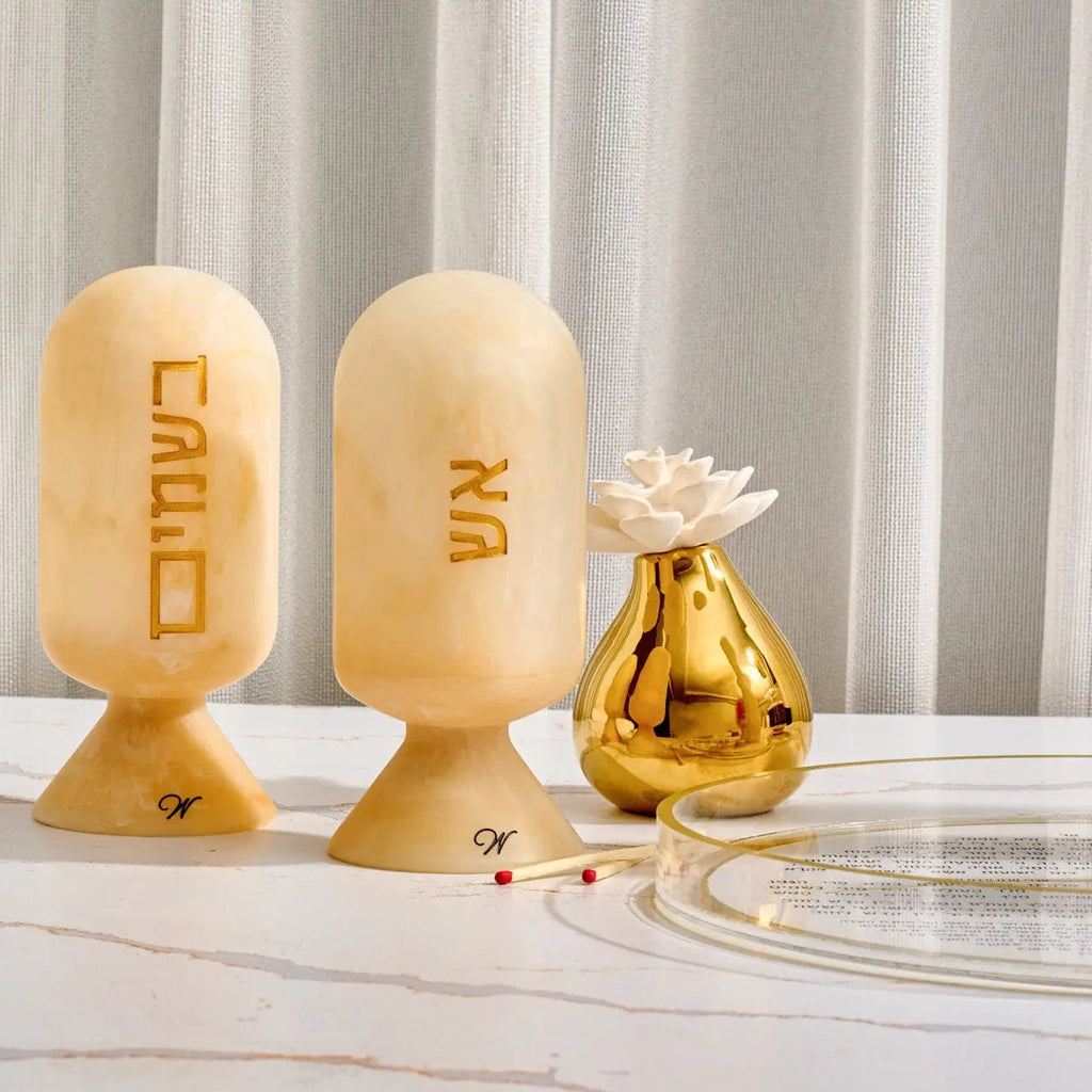 Wooden resin match cloche with carved Hebrew text, displayed with decorative gold bottle and glass, for Shabbat and havdalah use.