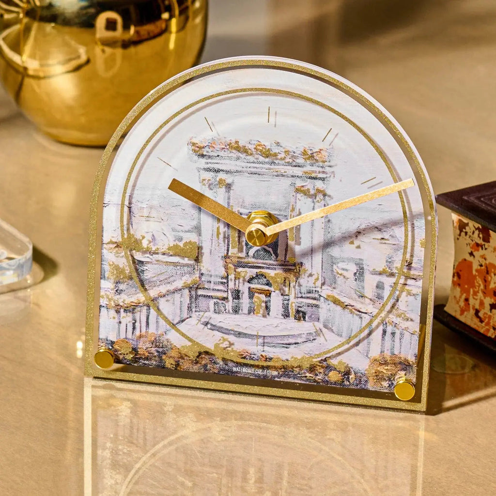 Bais Hamikdash desk clock with painted ceramic dome featuring Temple illustration, gold metal base, displayed on marble surface near decorative items.