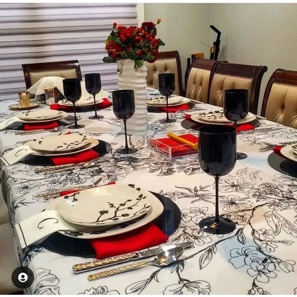 Black charger plates displayed on a formal dining table setting with red napkins and place settings for an elegant meal.