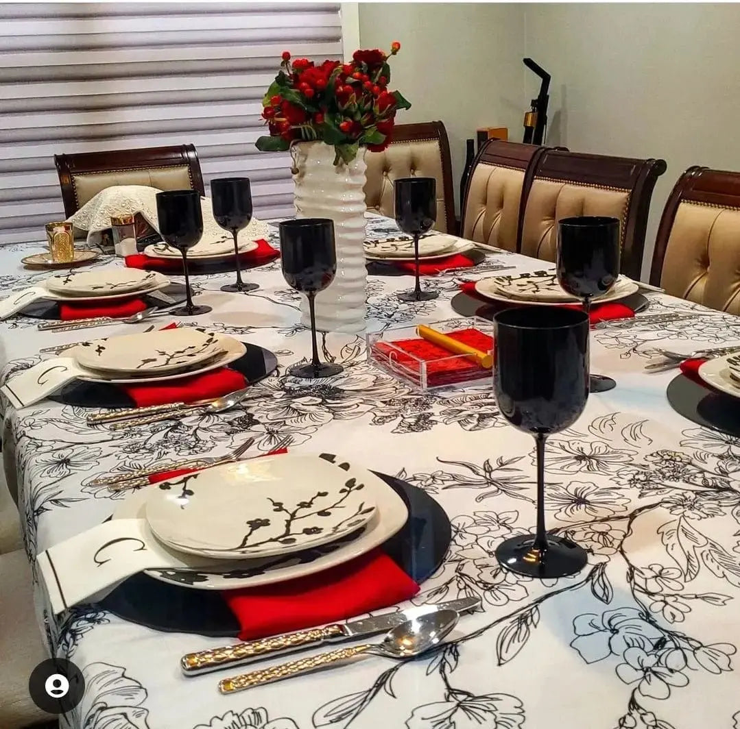 Black charger plates displayed on a formal dining table setting with red napkins and place settings for an elegant meal.