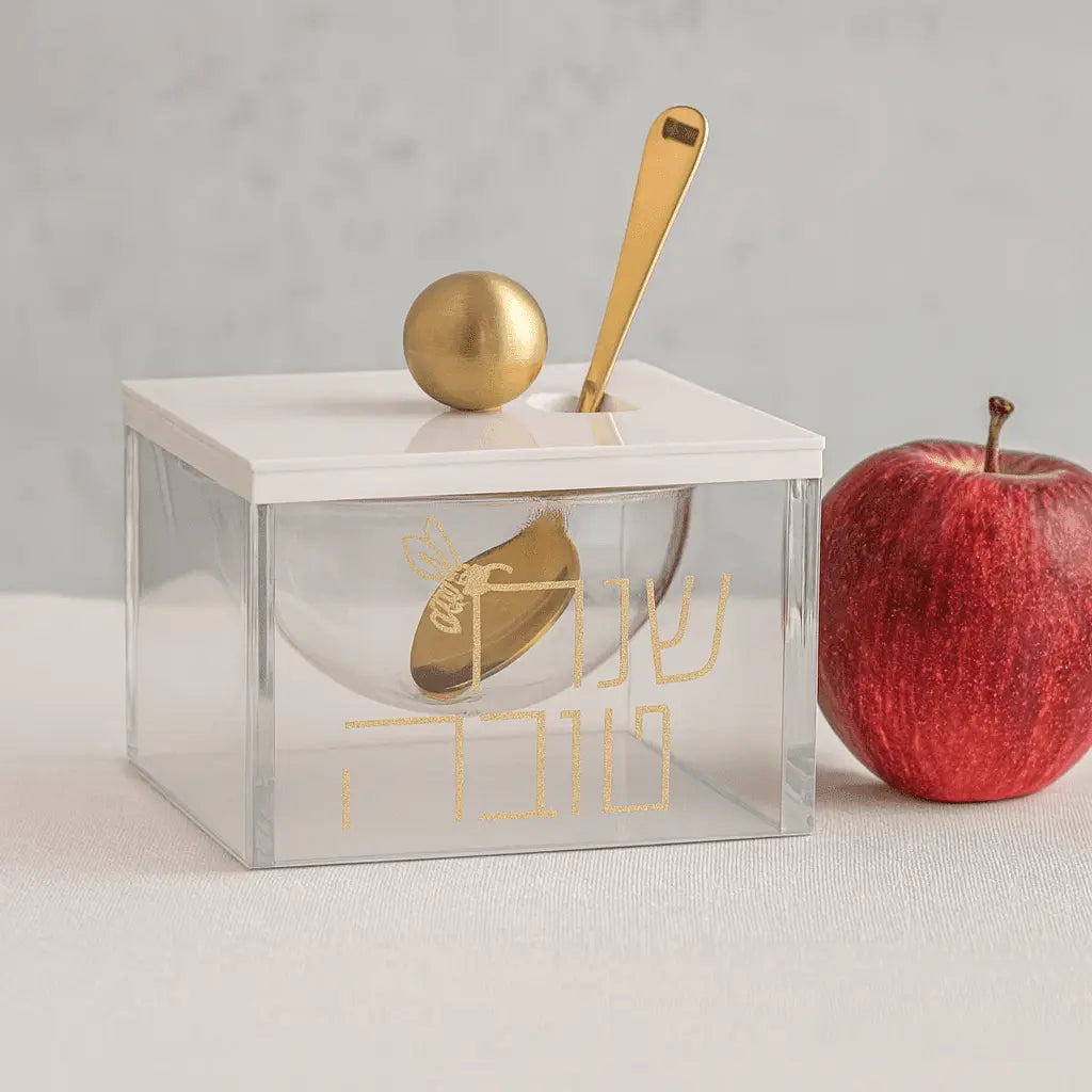 Block Honey Dish in clear acrylic with brass accents, shown with wooden honey dipper and red apple for scale, modern Judaica tabletop accessory