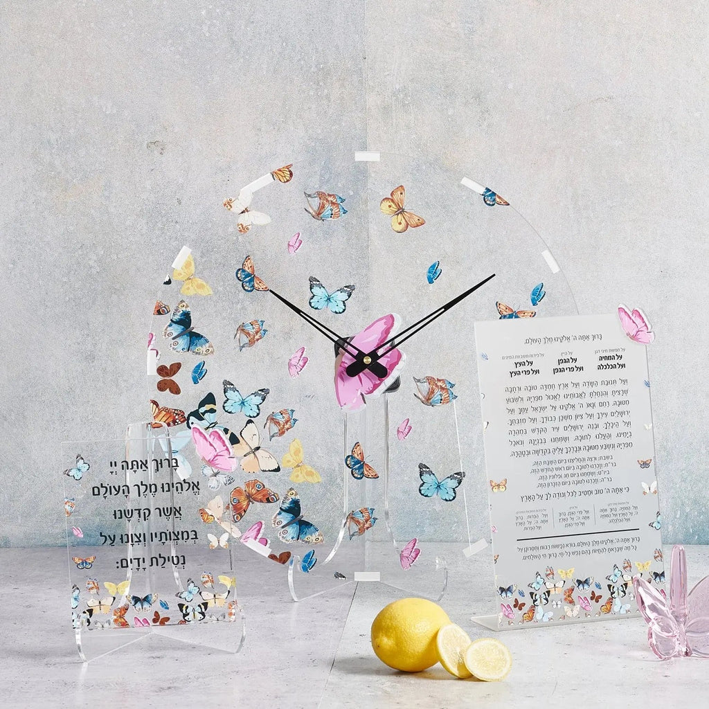 Waterdale Collection butterfly wall clock with colorful floral butterflies, white face, and black hands displayed on white wall with yellow lemon.