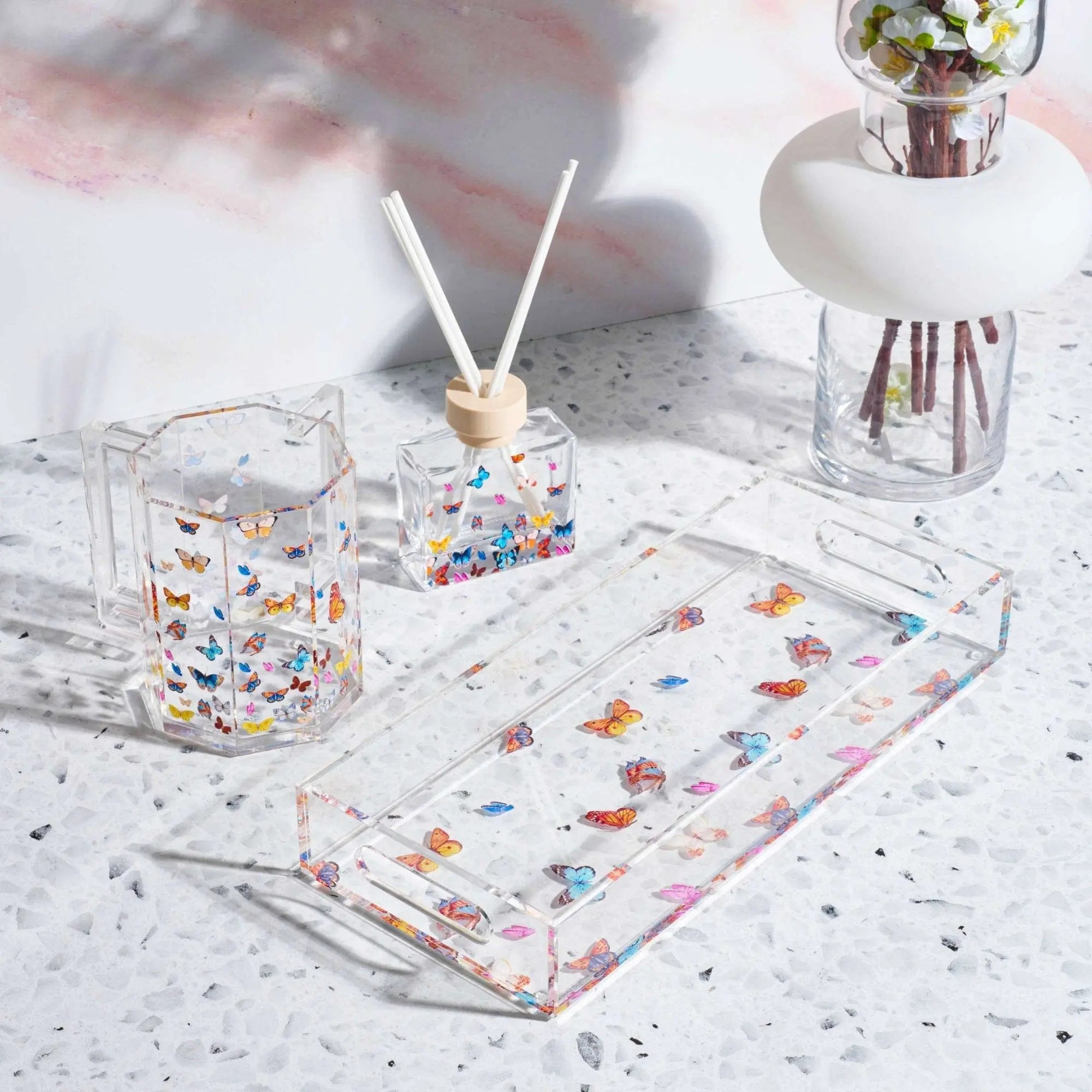 Clear butterfly diffuser with colorful confetti design, displayed with matching accessories on white speckled surface, perfect for home fragrance gifting.