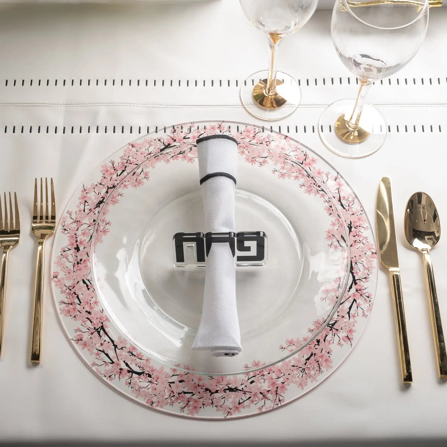 Cherry Blossom Charger plate with pink floral border and white center, set on formal place setting with white napkin and silverware