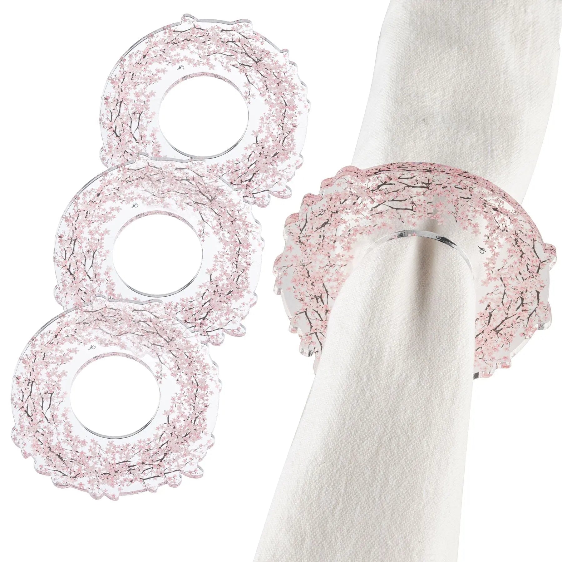 Three Cherry Blossom Napkin Rings in blush pink delicate wirework displayed on white napkins for elegant table settings.
