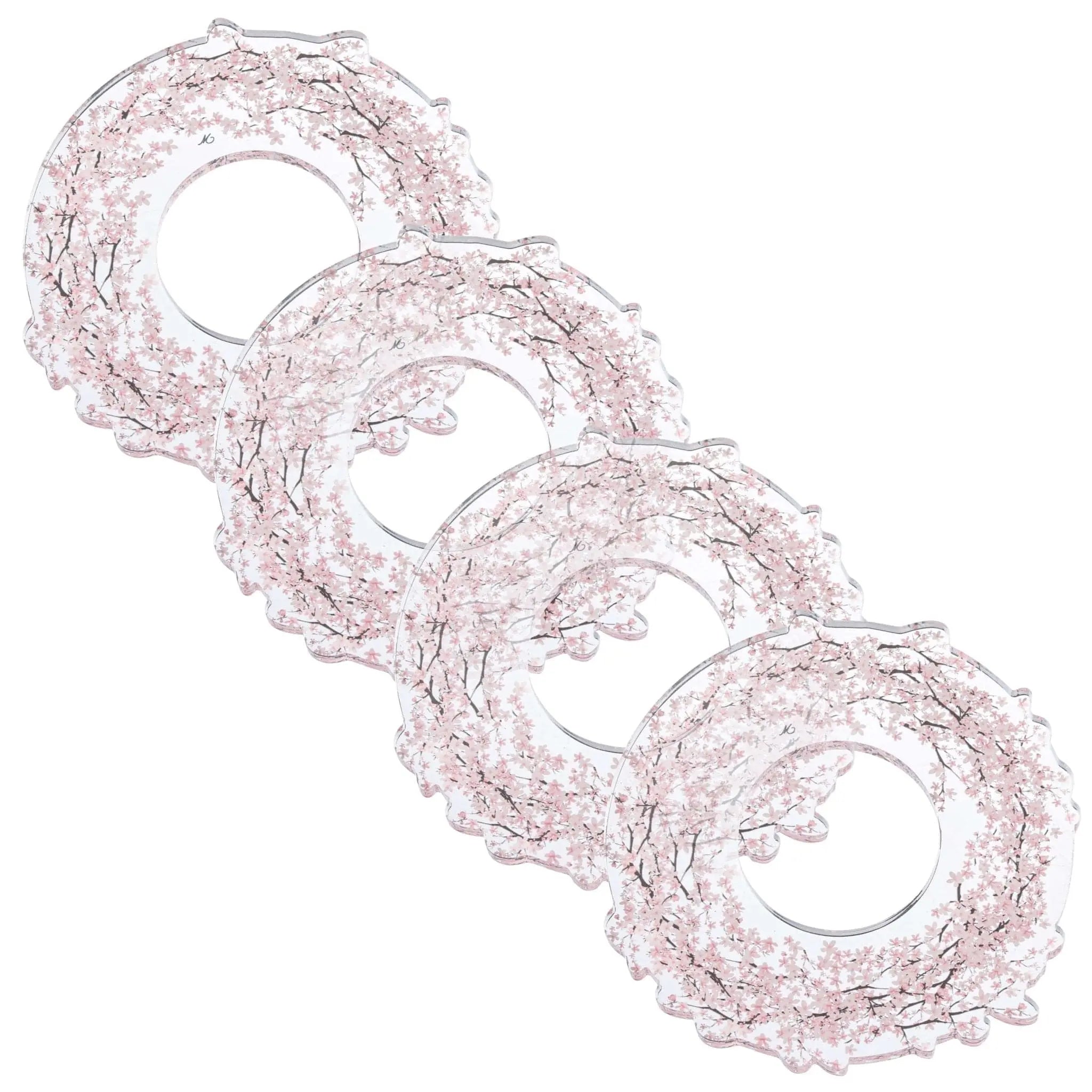 Four cherry blossom napkin rings with delicate pink floral details arranged in a diagonal line on white background.