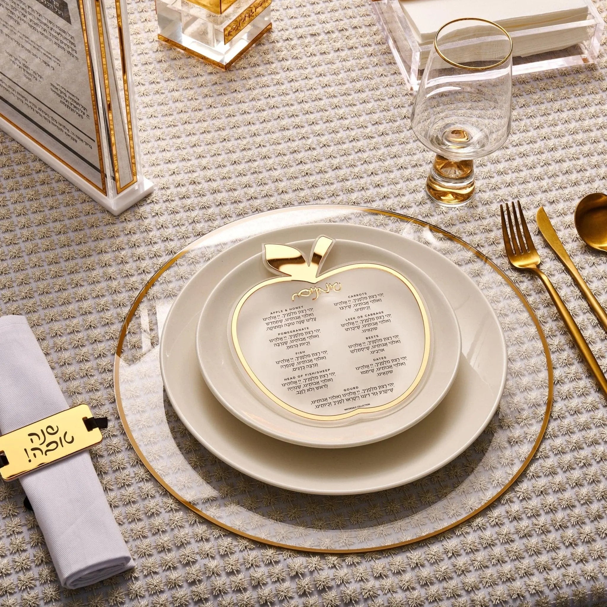 Classic Apple Simanim Card in clear lucite with gold accents, displayed on elegant table setting with place cards and dinnerware.