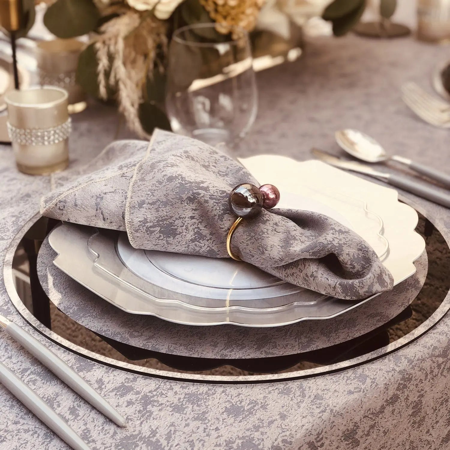 Classic Chargers with silver border and grey linen texture, layered place setting with napkin and cutlery detail