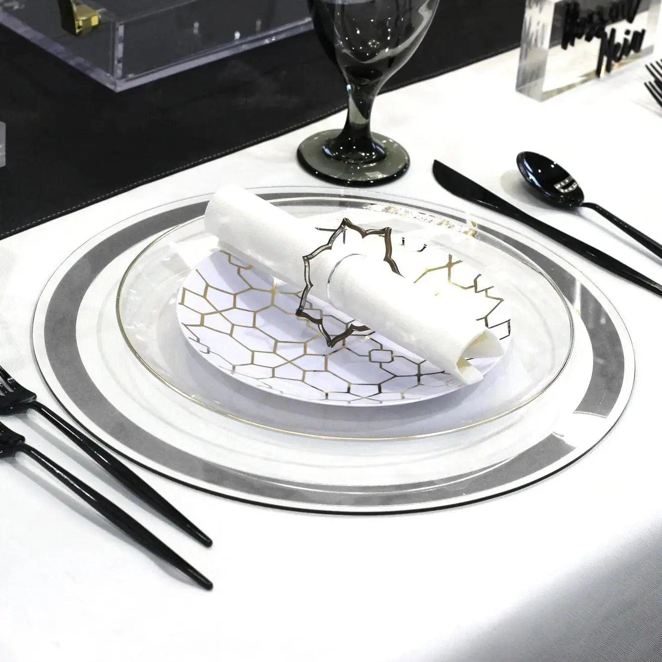 Classic Charger with silver border and intricate blue pattern detail, set at an elegant place setting with white plate and black utensils.