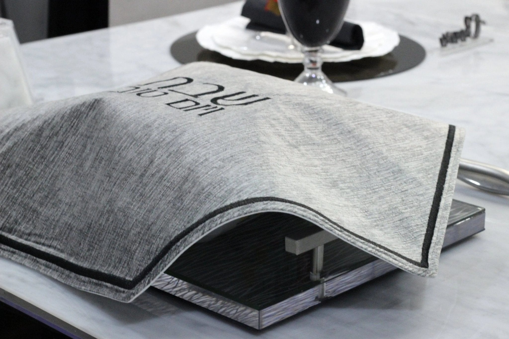 Gray crushed velvet hexagon challah cover with textured fabric detail, displayed flat on white surface for Shabbat table.