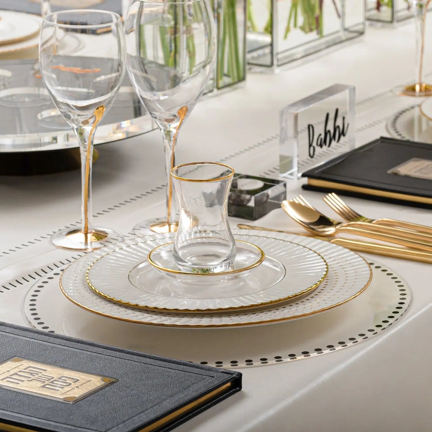 Dot border charger plate with silver beaded rim detail on elegant place setting with wine glass and dark napkin