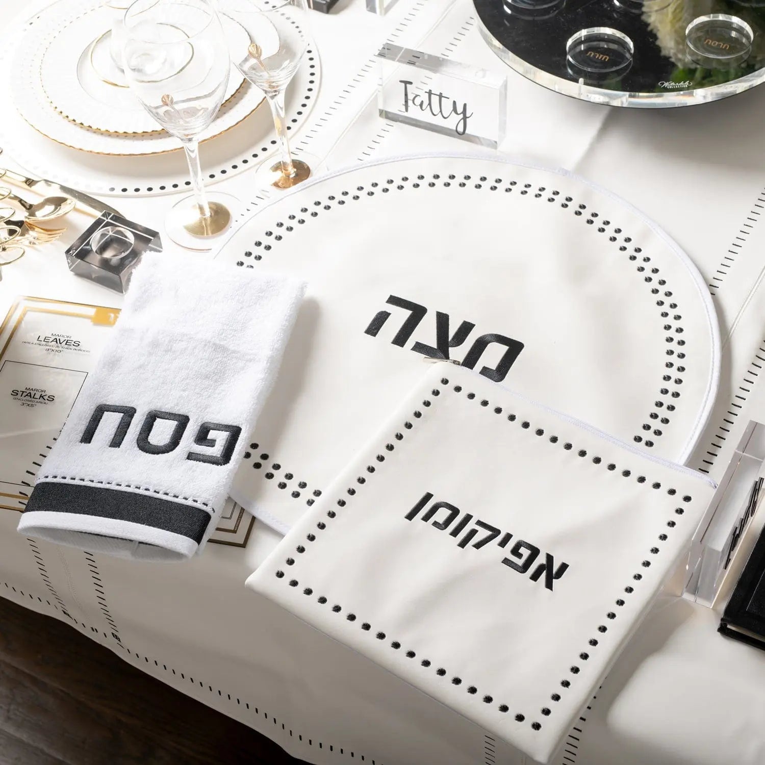Dot Border Pesach Set with white leather seder plate and matching items arranged on white surface with gold accents.