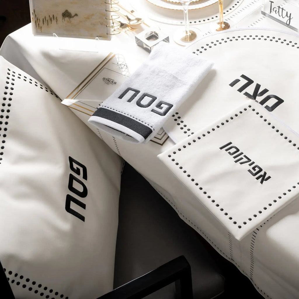 Dot Border Pesach Set in white leather with coordinating tableware displayed on a table setting, featuring elegant dotted design details.