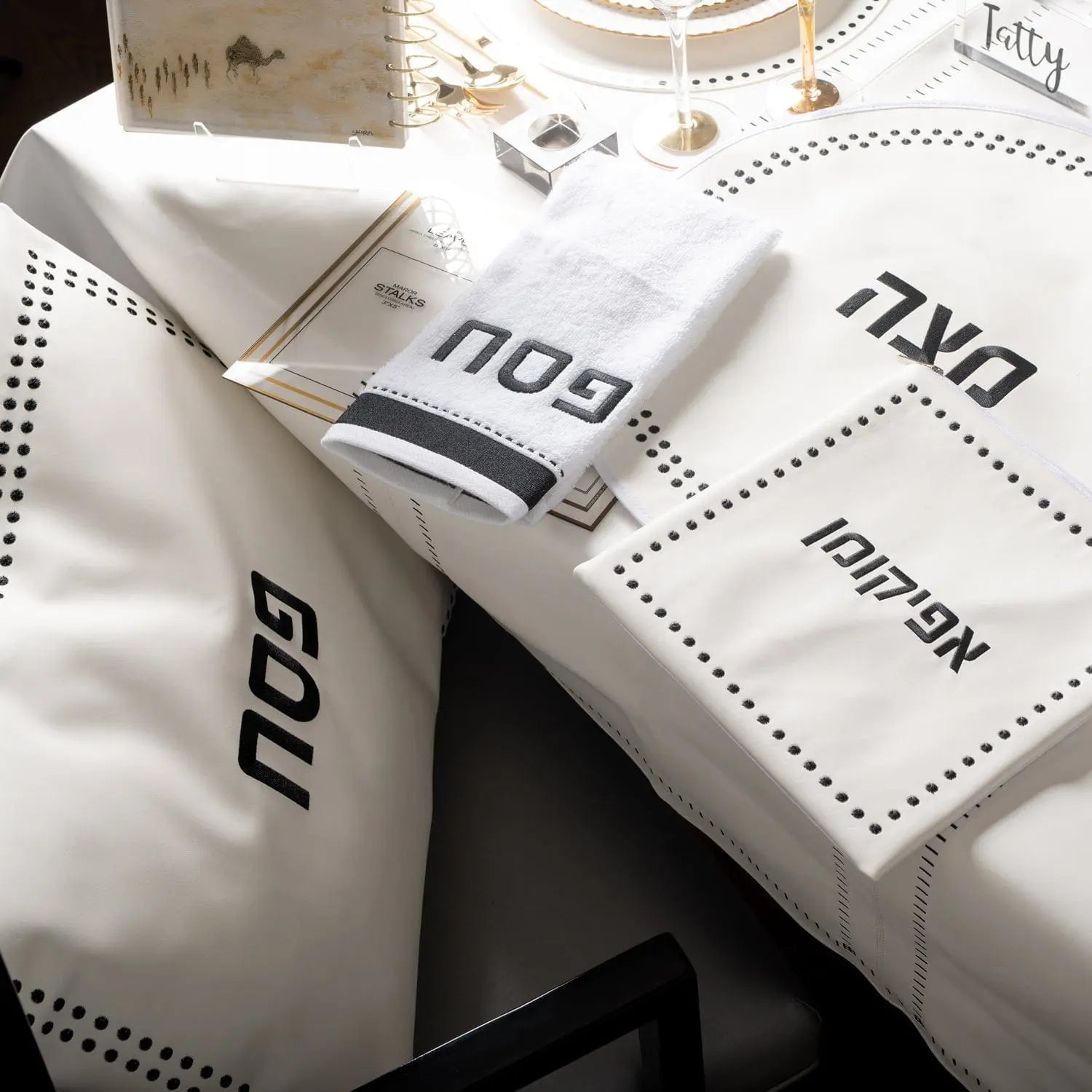 Dot Border Pesach Set in white leather with coordinating tableware displayed on a table setting, featuring elegant dotted design details.