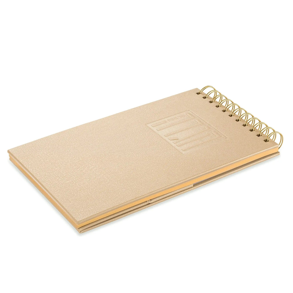 Tan leather Haggadah with spiral binding and embossed design, displayed open to show interior pages for Pesach table setting.