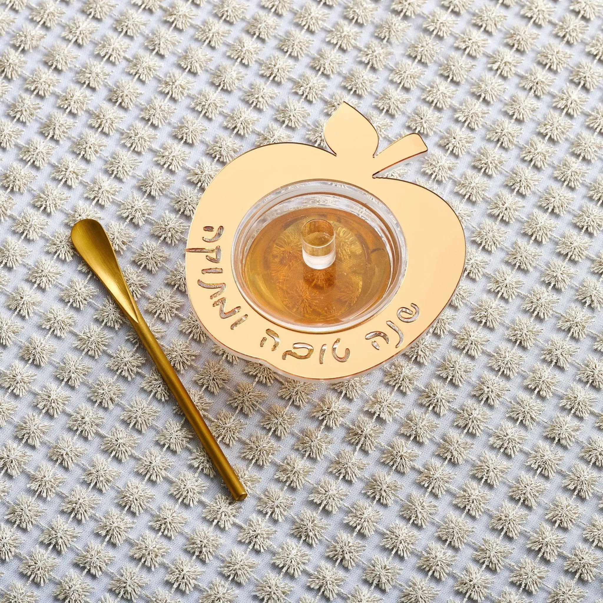 Ceramic floating apple honey dish in cream with golden interior and wooden honey dipper by Waterdale Collection.
