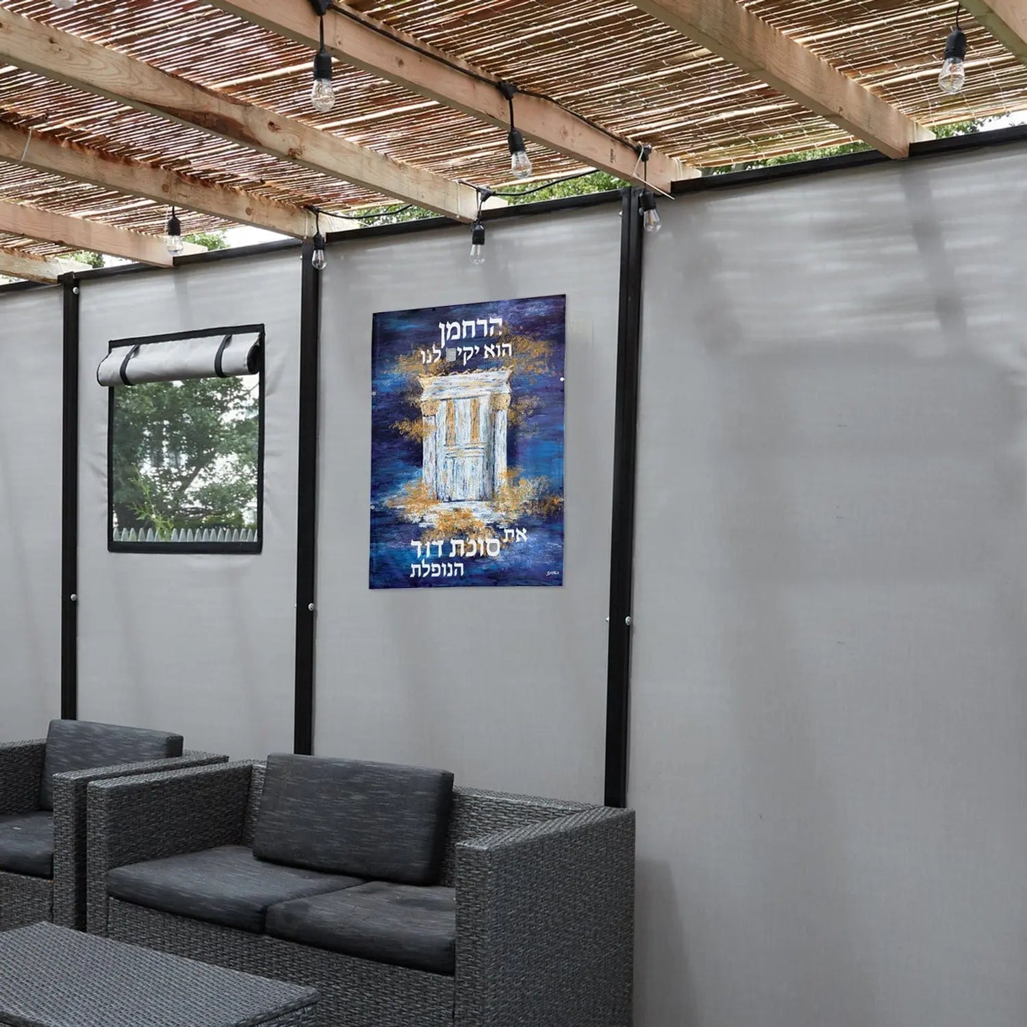 Harachamun vinyl sukkah decoration poster displayed in decorated sukkah space with seating area