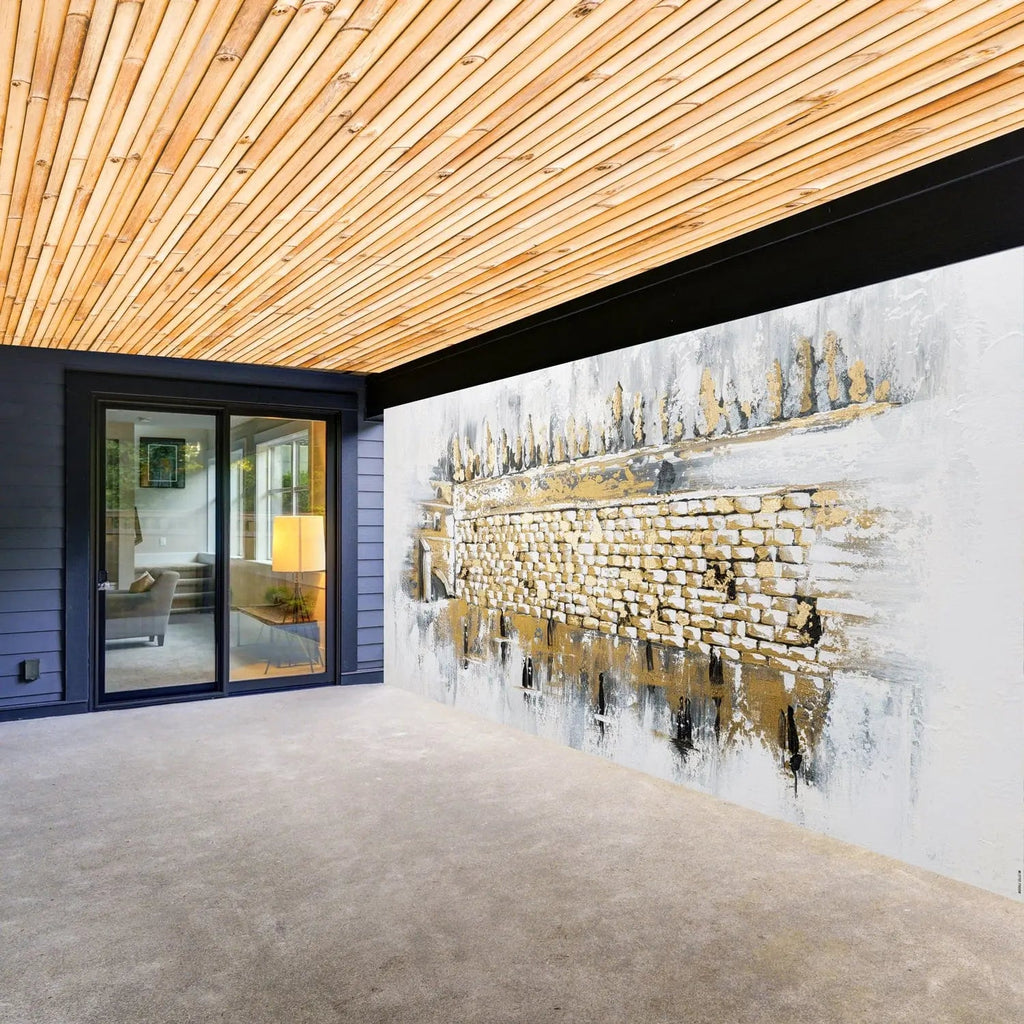 Kosel at Winter vinyl sukkah decoration featuring a golden cityscape design on white background, displayed on sukkah wall with wooden ceiling visible.