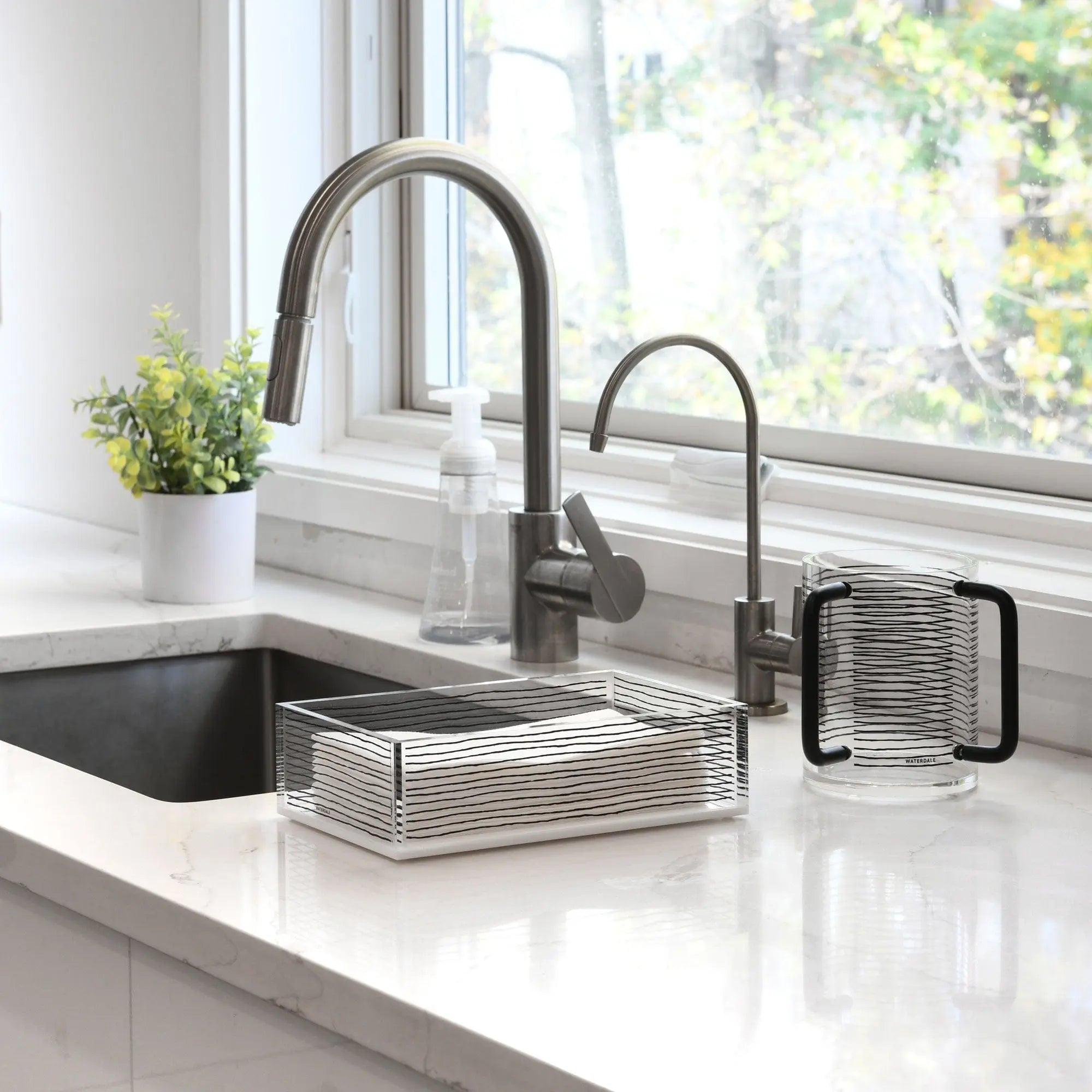 Brushed metal KS Inspired Guest Towel Holder displayed on a white bathroom vanity next to a sink faucet and soap dispenser.
