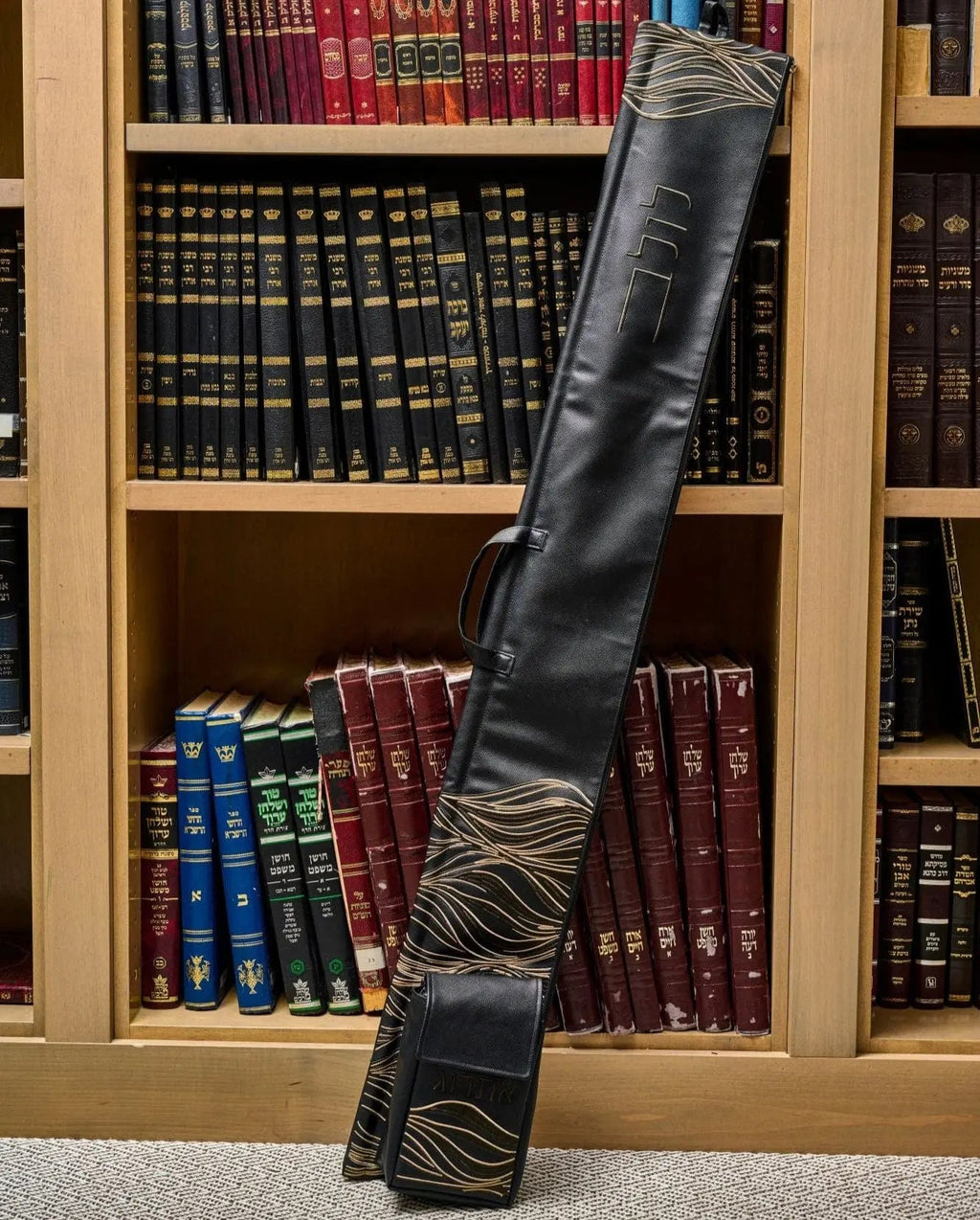 Black leather Lace Lulav and Esrog Case by Waterdale Collection with decorative lace detailing, displayed against bookshelf backdrop.