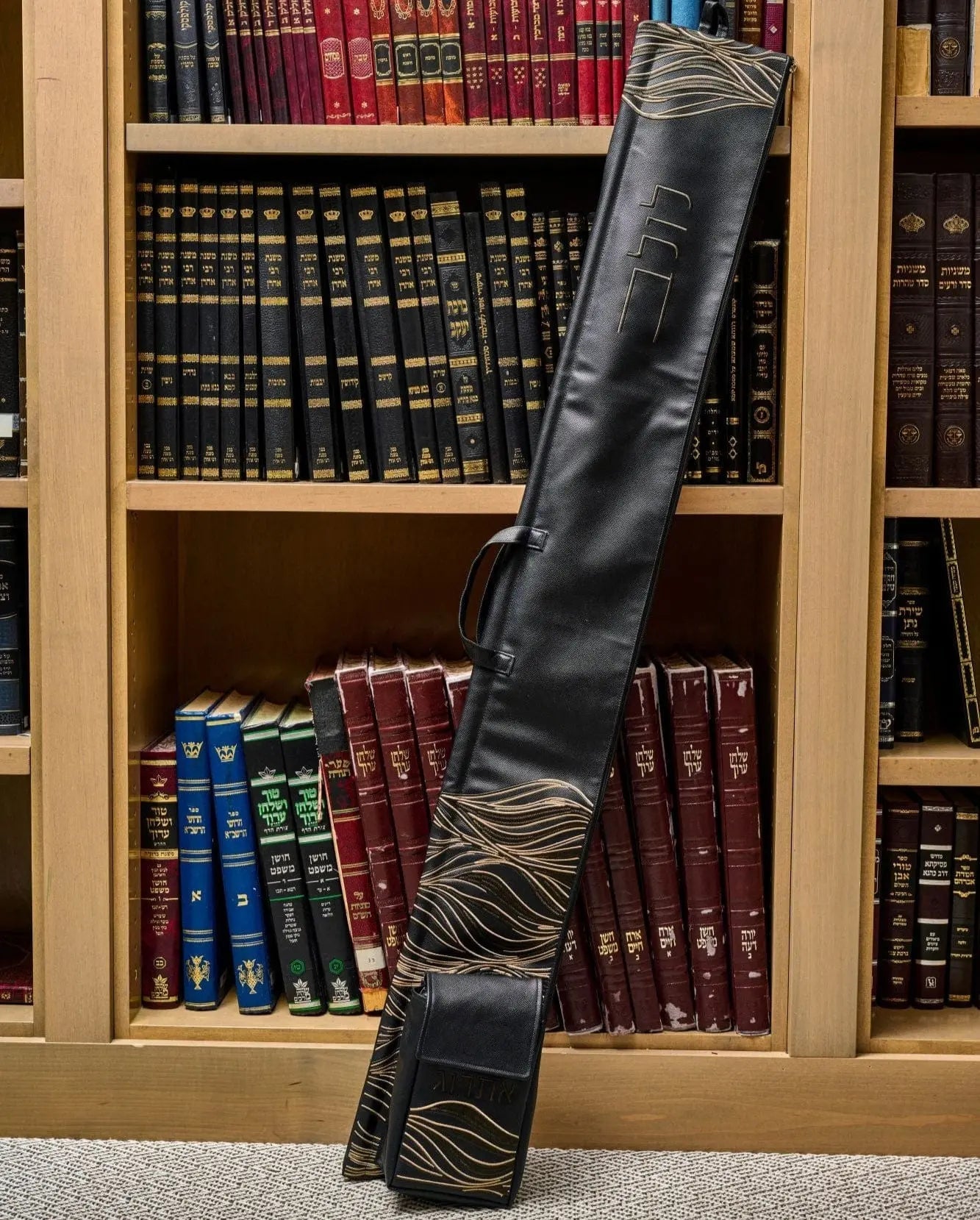 Black leather Lace Lulav and Esrog Case by Waterdale Collection with decorative lace detailing, displayed against bookshelf backdrop.