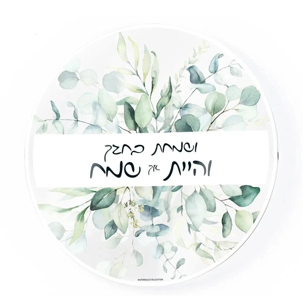 Waterdale Collection leaf sukkah decorations featuring painted eucalyptus sprigs and Hebrew text on white circular design for Sukkot holiday decor.