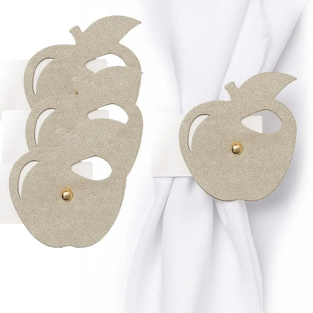 Gold leatherette apple-shaped napkin rings holding white napkins, festive table decor from Waterdale Collection