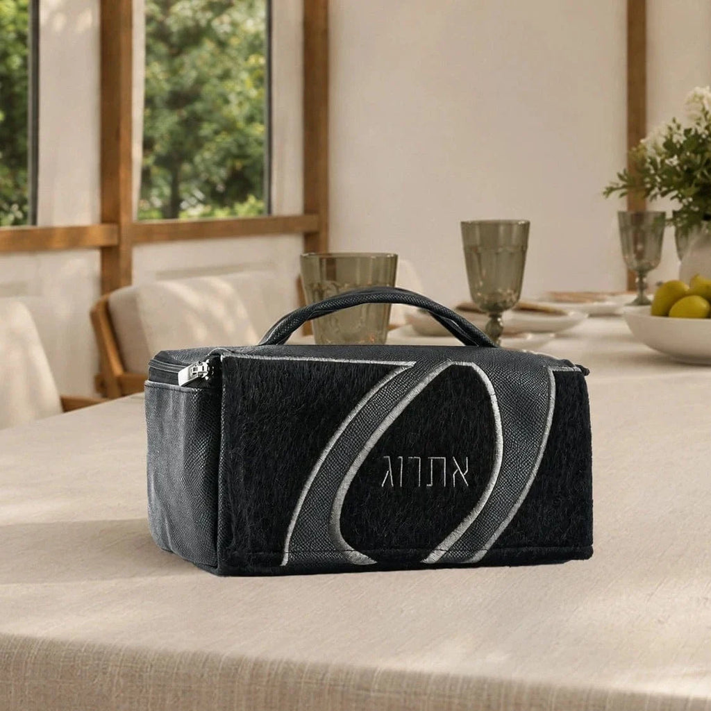 Plush fur, a sweeping leather loop and embossed Hebrew lettering give this Sukkos esrog case its look. Black and navy. 
