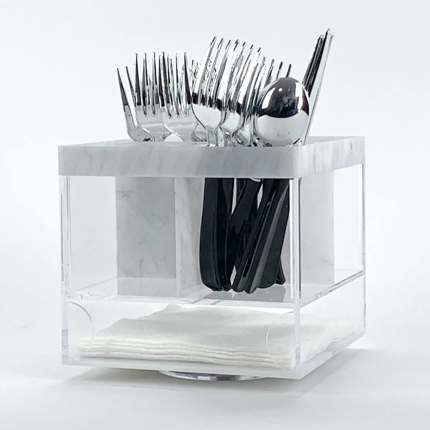 Marble swivel silverware caddy with clear compartments holding forks, knives, and spoons, rotating base design for easy access.