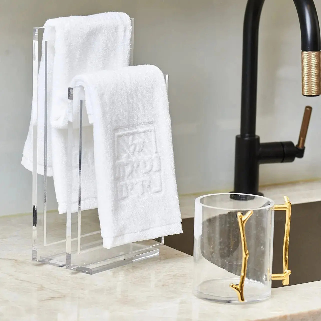 MetaLucite Twig Washing Cup in brushed metal with white towels displayed on marble countertop near sink area