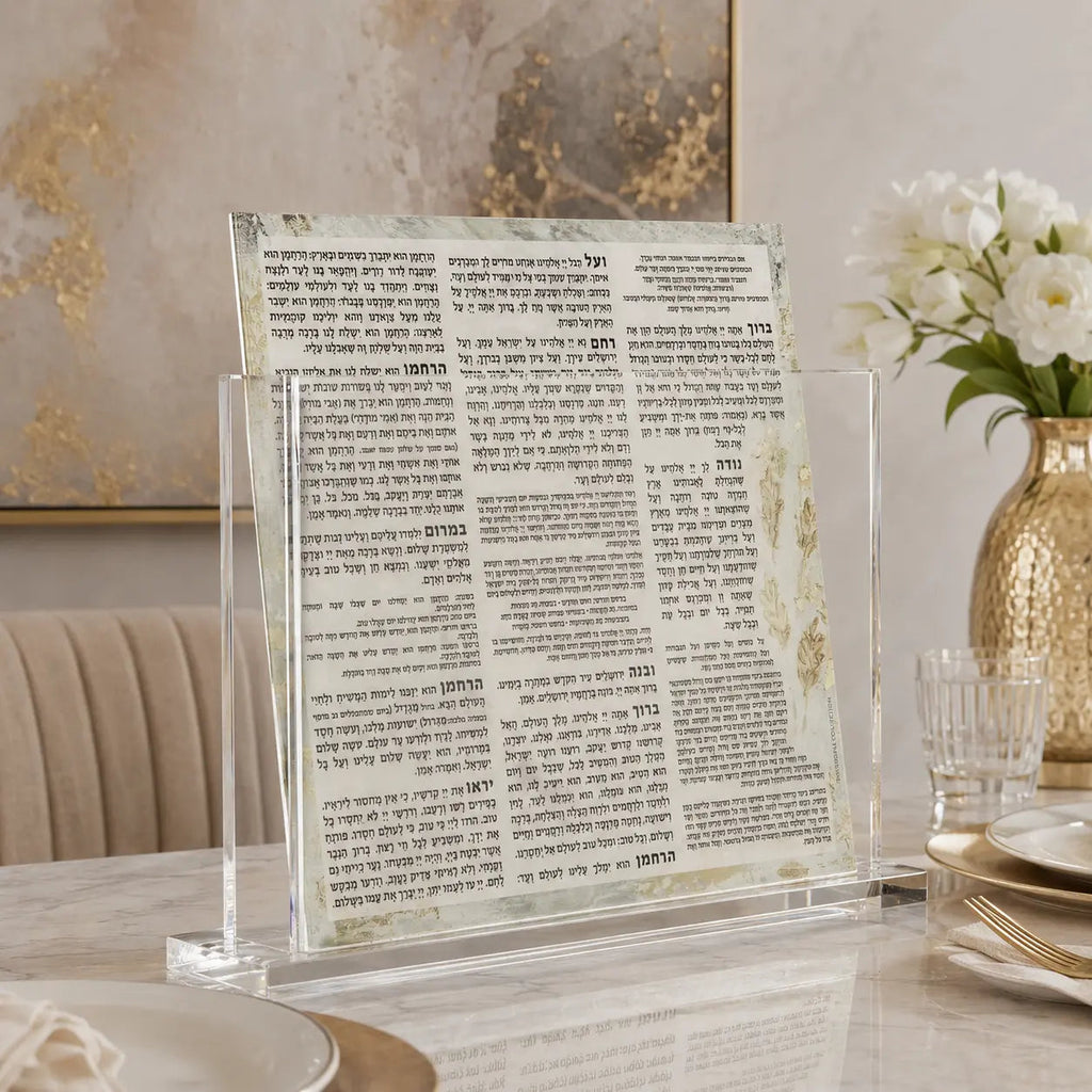 White painted bencher set displayed on table with flowers and place setting, featuring Jewish prayer text for Birchat Hamazon.