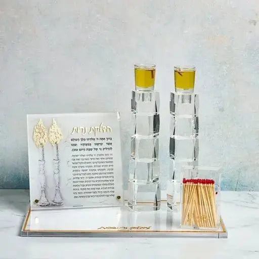 Painted by Judy tabletop plaque for Shabbat candle lighting featuring glass candlestick holders, matches, and illustrated prayer card on marble base.