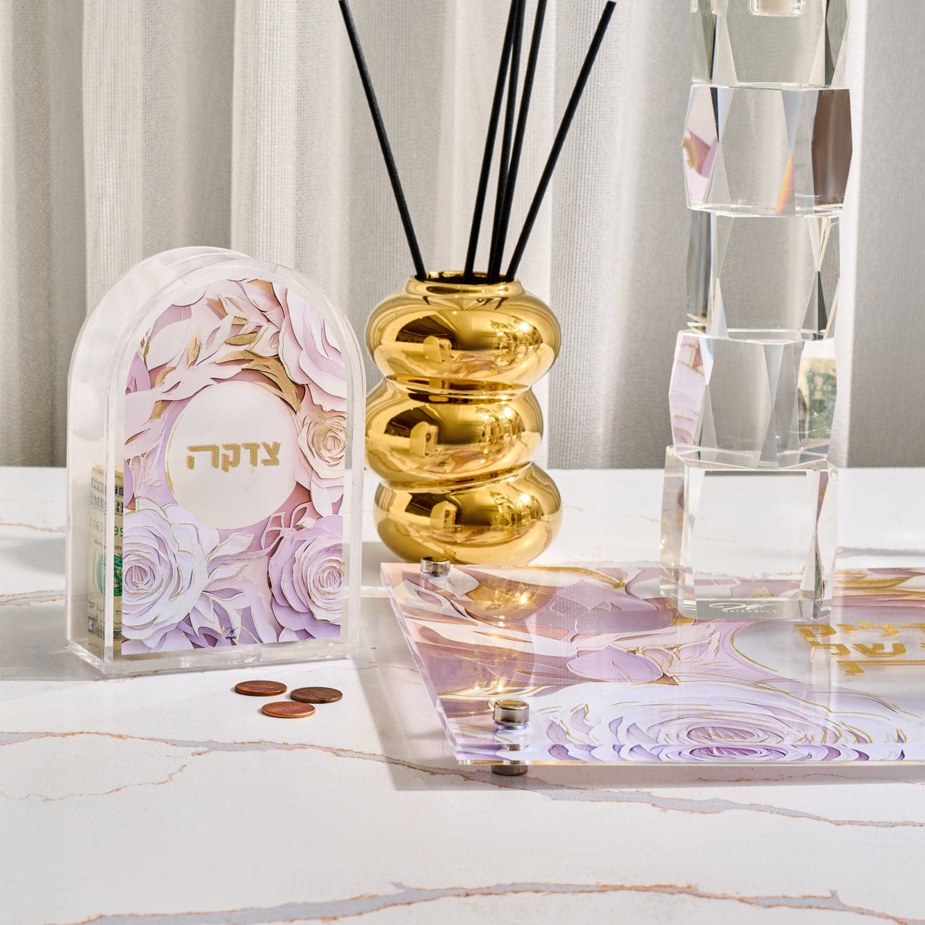 Papercut Tzedakah box with an intricate white and gold floral design.