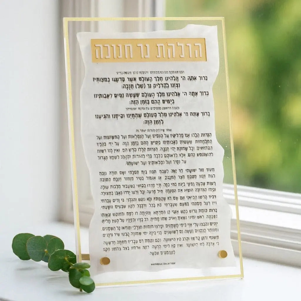 Pearlstone Tabletop Chanukah Brachos plaque with Hebrew text on pearl marble, displayed on white windowsill with green plant.
