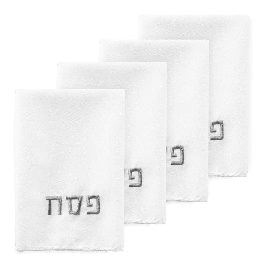 Four white Pesach napkins with Hebrew text displayed in a fanned arrangement showing the folded napkins for holiday table settings.