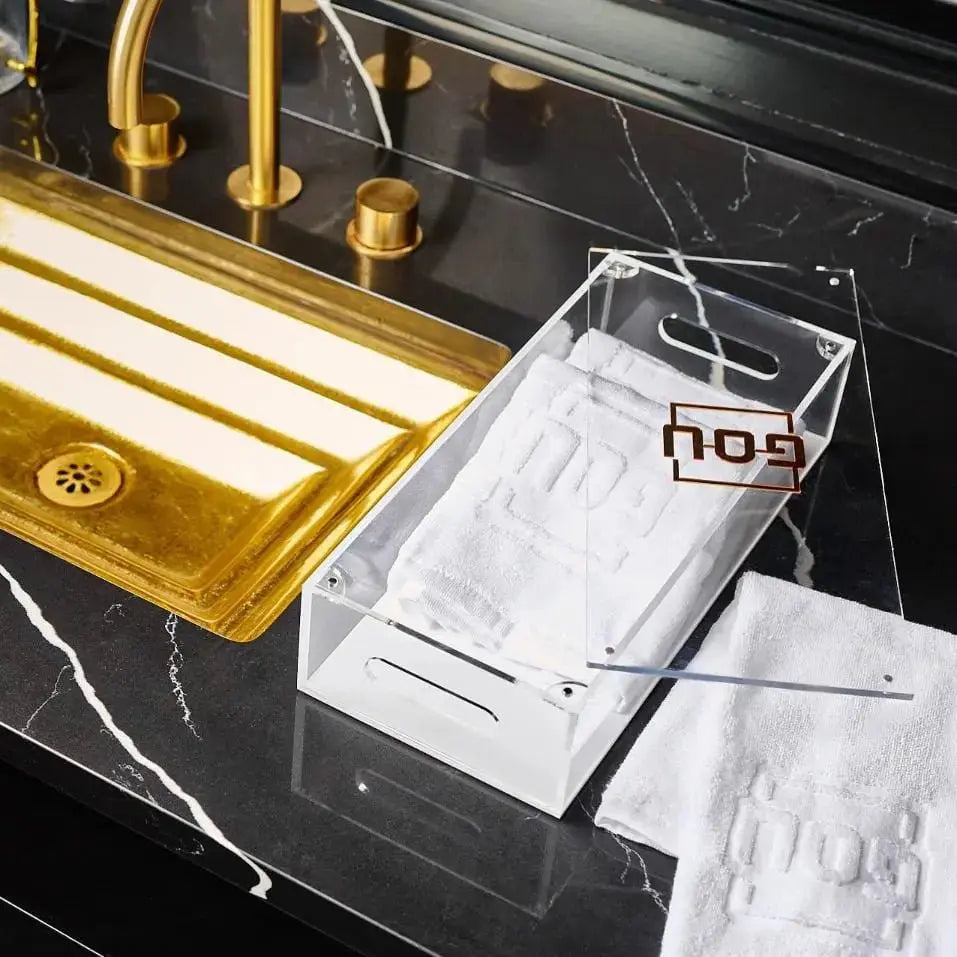 Pesach towel box with white towels and gold accents displayed on marble surface with lucite tray