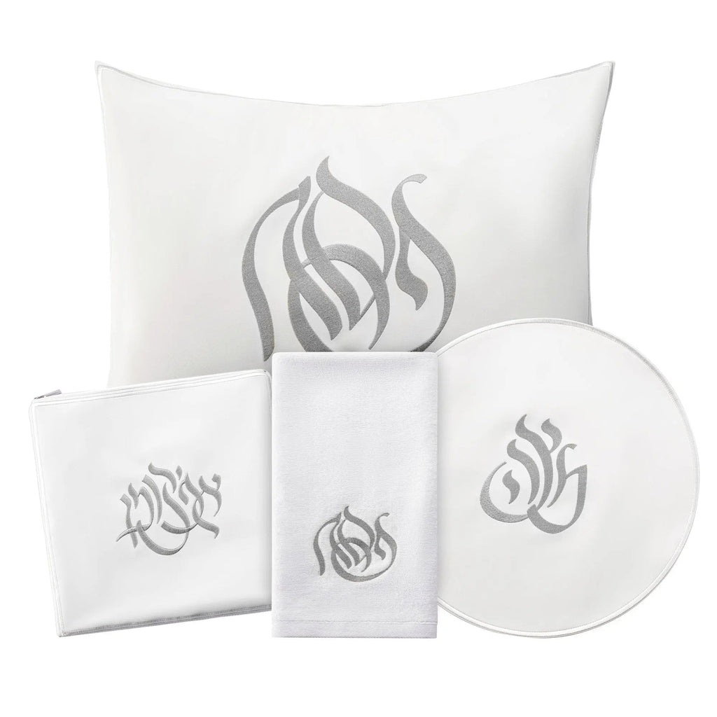 Regal Pesach Set in white and silver leather featuring matching placemats, napkin holder, and circular coasters with decorative flame design.