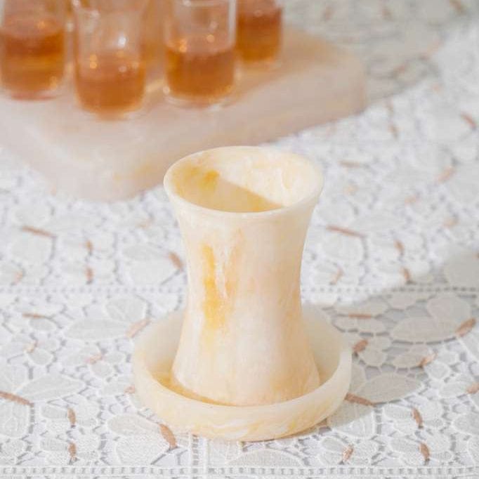 Decorative Kiddish cup on a lace tablecloth with small jars in the background - Waterdale Collection