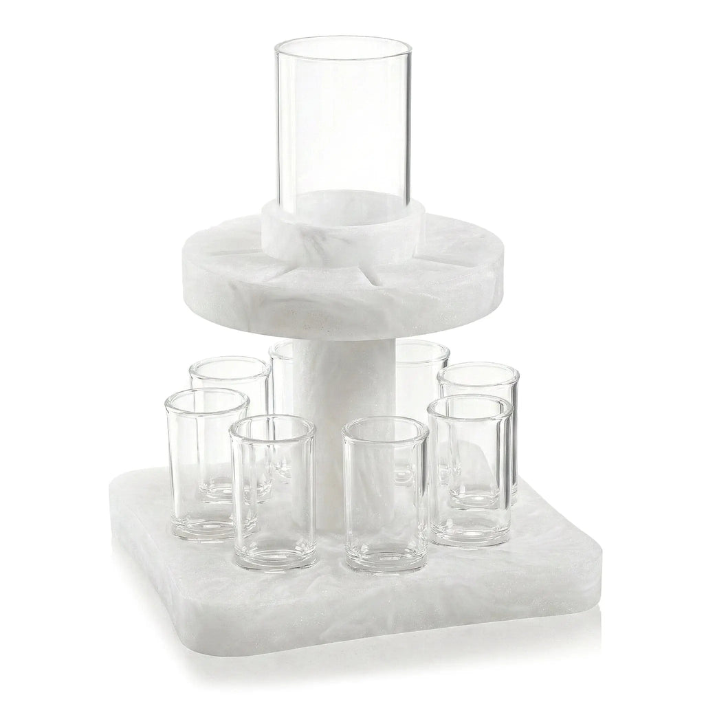 Resin Kiddush fountain with clear glass cups arranged on tiered white base for Shabbat wine service.