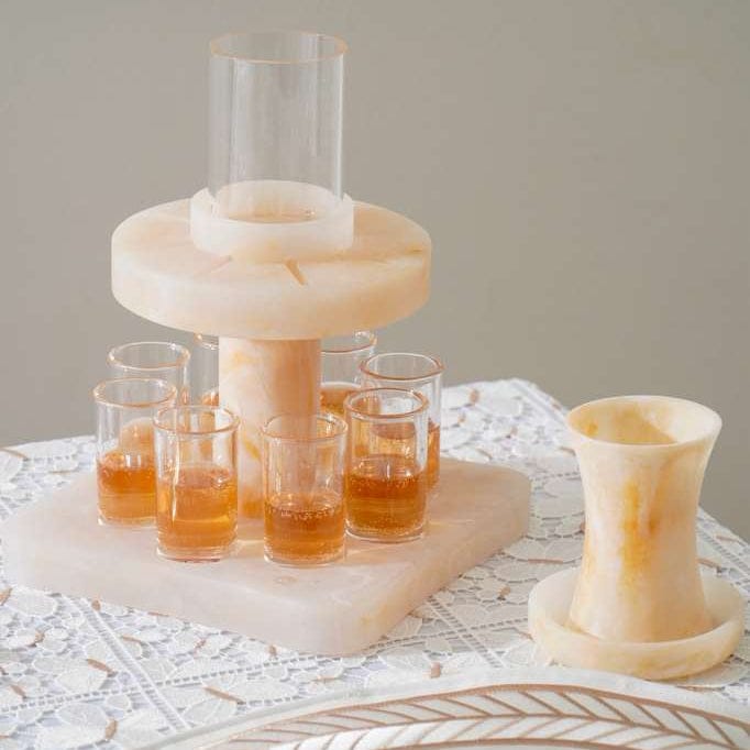 Kiddush Wine dispenser with glasses on a textured surface - Waterdale Collection